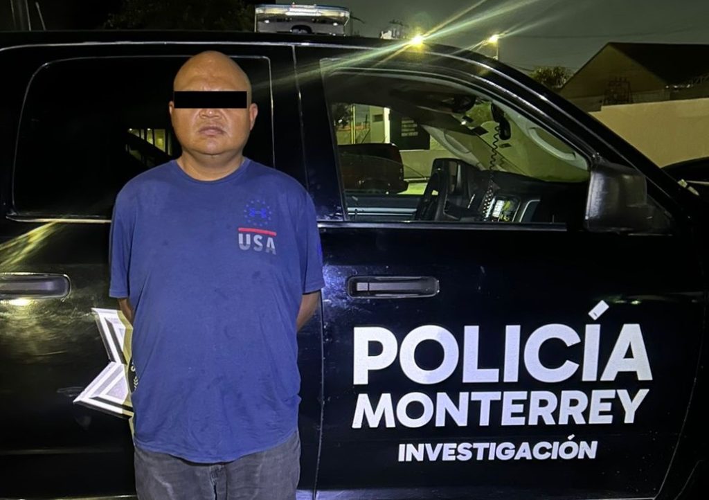 Man with Blacked-out Eyes Stands Next to a Policía De Monterrey Vehicle at Night, Wearing a Blue Usa Shirt, Signaling a Police Arrest/detention Scenario. - Nuevo León Primero