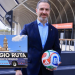Adrian-de-la-garza-y-el-mundial - Nuevo León Primero Man in a Blue Blazer Holds a Colorful Soccer Ball at a Stadium Entrance; Inset Shows a Purple Regio Ruta Bus with a Church in the Background. - Nuevo León Primero