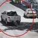 Surveillance Frame of a White Pickup Truck in the Middle of a Street, Circled in Red, with a Beige Car Nearby and Bystanders on the Sidewalk. - Nuevo León Primero