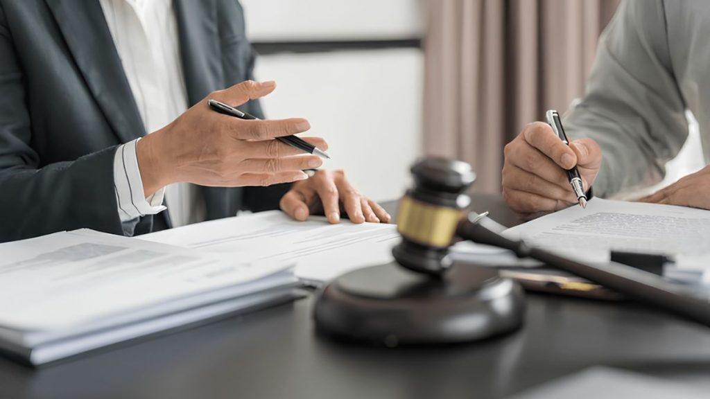 Cateo-contrato-quantium-desarrollos - Nuevo León Primero Two Professionals Sign Documents at a Desk, with a Gavel in the Foreground. - Nuevo León Primero