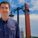 Secretario-de-administracion-de-monterrey - Nuevo León Primero Man in a Navy Button-down Shirt Stands Outdoors in Front of Ornate Street Lamps and a Red Decorative Pillar, Blue Sky Behind Him. - Nuevo León Primero