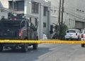 Armored Police Vehicle Blocking a Residential Street Behind Yellow Caution Tape, with Investigators and Piled Bags Near a Building Corner. - Nuevo León Primero