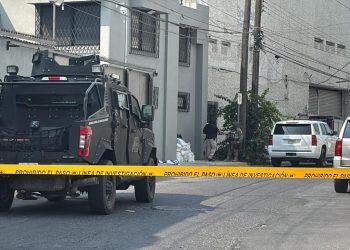 Armored Police Vehicle Blocking a Residential Street Behind Yellow Caution Tape, with Investigators and Piled Bags Near a Building Corner. - Nuevo León Primero