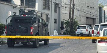 Armored Police Vehicle Blocking a Residential Street Behind Yellow Caution Tape, with Investigators and Piled Bags Near a Building Corner. - Nuevo León Primero