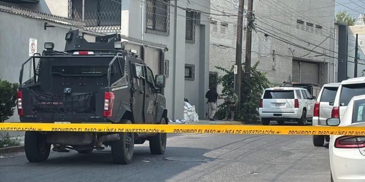 Armored Police Vehicle Blocking a Residential Street Behind Yellow Caution Tape, with Investigators and Piled Bags Near a Building Corner. - Nuevo León Primero