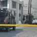 Armored Police Vehicle Blocking a Residential Street Behind Yellow Caution Tape, with Investigators and Piled Bags Near a Building Corner. - Nuevo León Primero